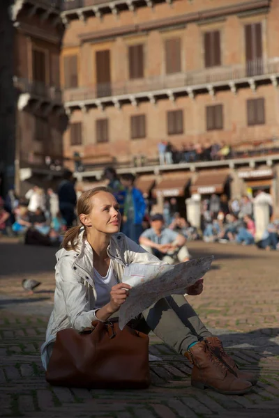 Underbar kvinnlig turist med en karta att upptäcka en främmande stad — Stockfoto