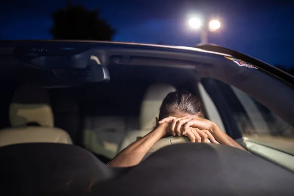 Jonge vrouwelijke bestuurder aan het stuur van haar auto, super moe — Stockfoto