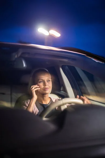 Молодая женщина-водитель играет со своим телефоном — стоковое фото