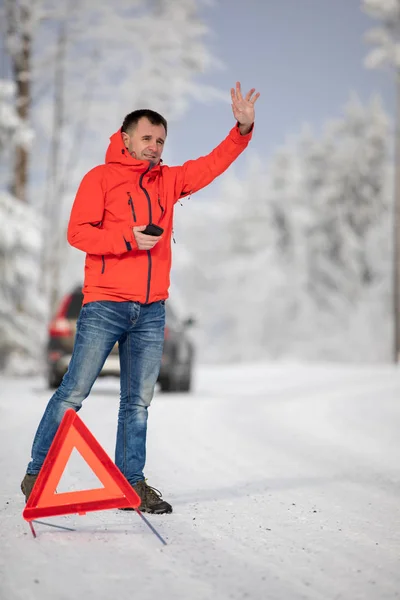 Jóképű ember felállítása figyelmeztető háromszög, és felszólította a segítséget — Stock Fotó