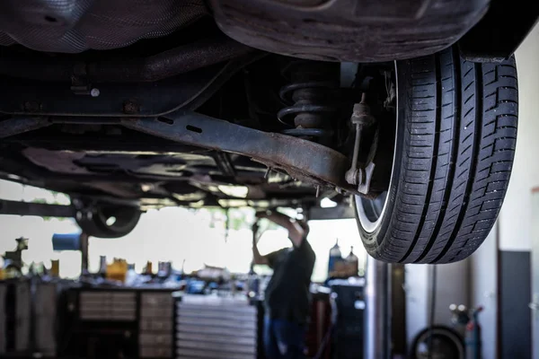 Car in a garage for maintenance, oil/tyre change — Stock Photo, Image