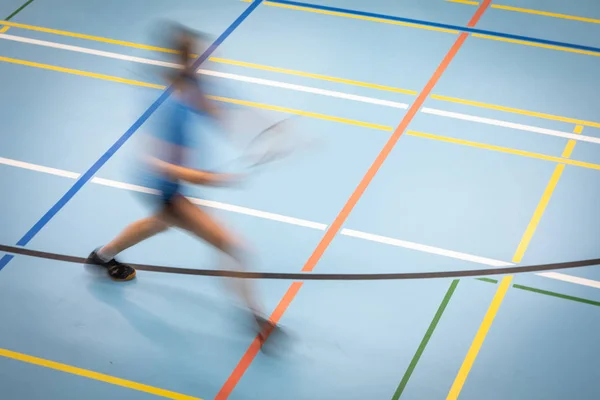 Jogador de badminton em movimento rápido em uma quadra de badminton — Fotografia de Stock