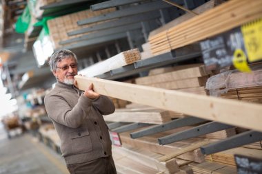 Adam seçimi ve onun için bir Diy mağazasında inşaat ahşap satın