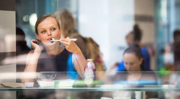 Vacker, ung kvinna äta sushi på en restaurang — Stockfoto