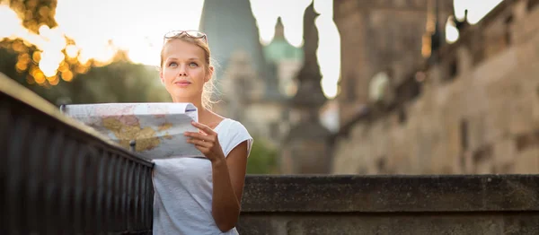 Jolie jeune touriste féminine étudiant une carte — Photo