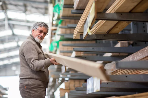Man choosing and buying construction wood in a DIY store for his — Stock Photo, Image