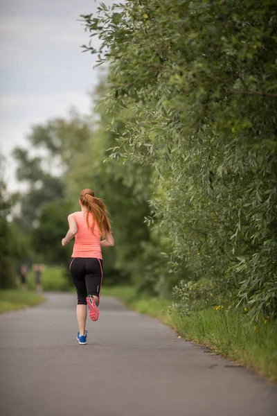 Mujer joven corriendo al aire libre en un hermoso día soleado de invierno / otoño —  Fotos de Stock