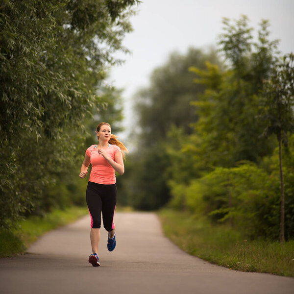 Young woman running outdoors on a lovely sunny winter/fall day