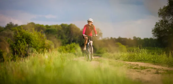 Ciclista feminino ao ar livre em sua bicicleta de montanha — Fotografia de Stock