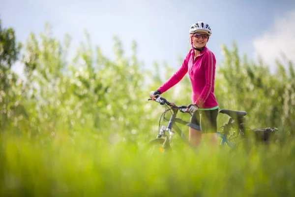 Велосипедистка на природе на своем горном велосипеде — стоковое фото
