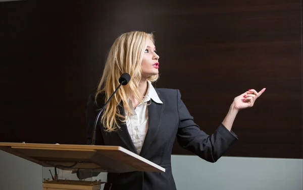 Mujer de negocios bonita y joven dando una presentación en una conferencia — Foto de Stock