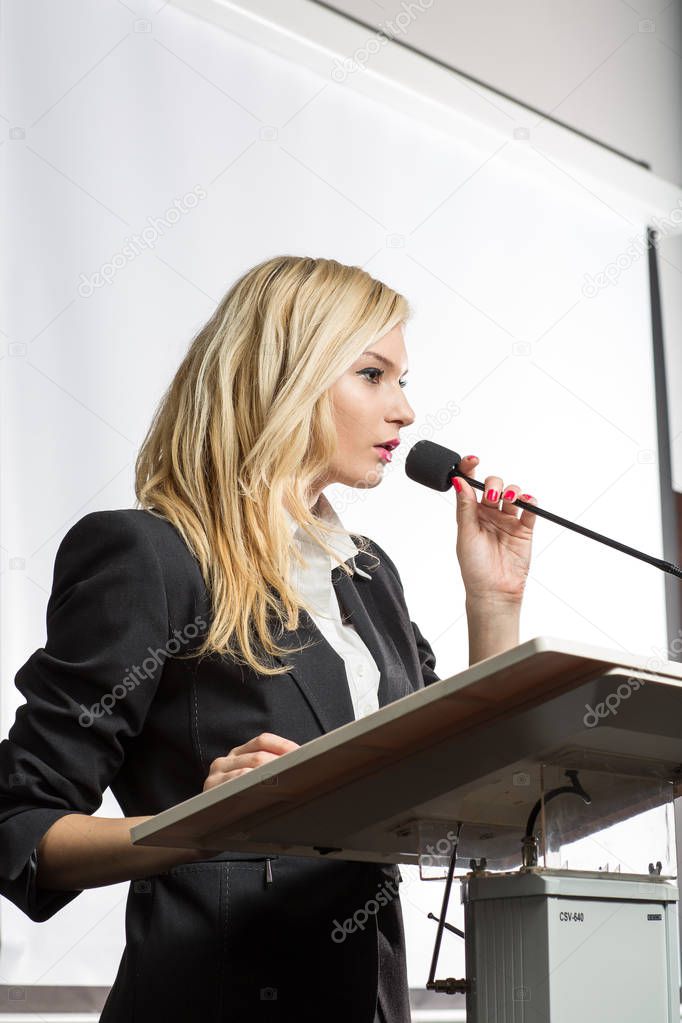 Pretty, young business woman giving a presentation in a conference