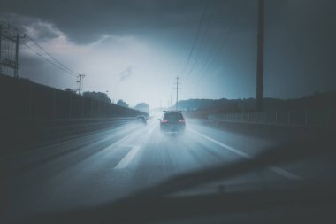 Yağmurlu bir alacakaranlıkta bir otoyolda arabalar