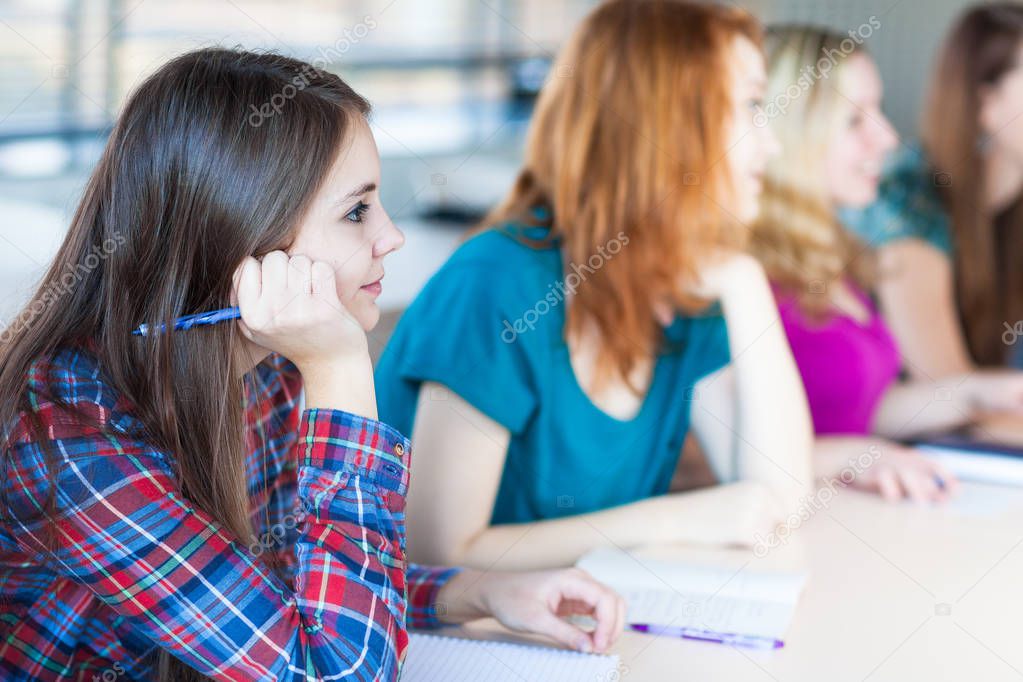 Students in classroom - young pretty female college student sitt
