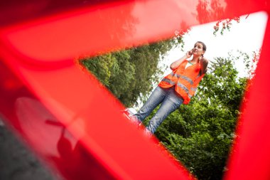 Genç bayan sürücü yol kenarındaki servisi arıyor.