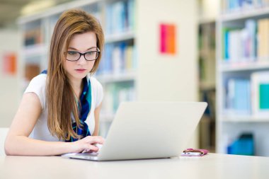 Seyir için bir kitap güzel, kadın üniversite öğrencisi bir Kitaplığı ' nda 