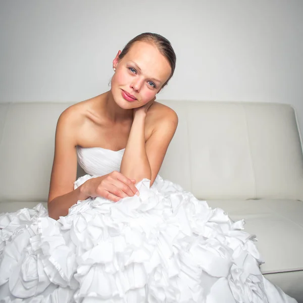 Super tired gorgeous bride sitting on a sofa after a long weddin — Stock Photo, Image