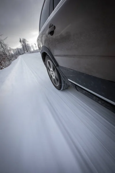겨울의 고산 지대의 눈덮인 도로에서 빠르게 달리는 자동차 — 스톡 사진