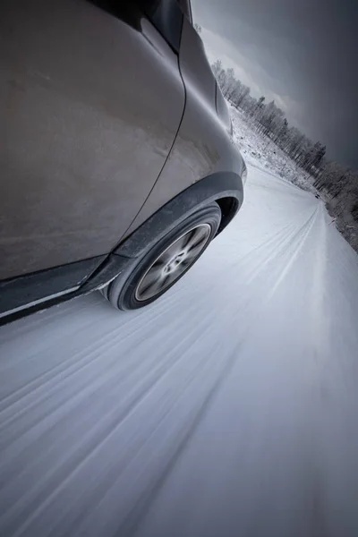 겨울의 고산 지대의 눈덮인 도로에서 빠르게 달리는 자동차 — 스톡 사진