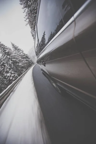 Fast moving car on a winter alpine snowy road — Stock Photo, Image