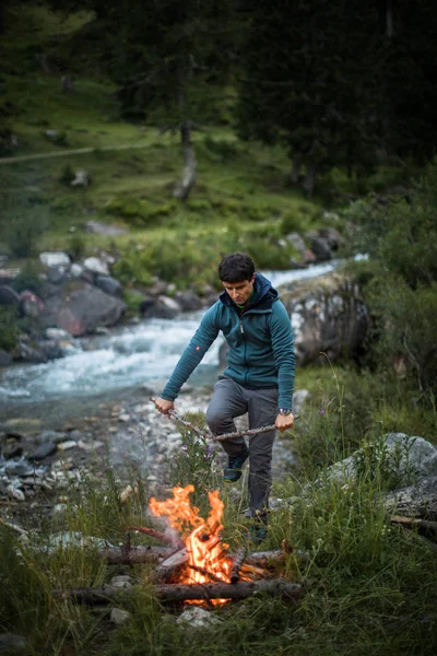 Młody człowiek robi ogień podczas kempingu na zewnątrz — Zdjęcie stockowe