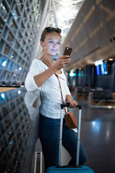 Νεαρή γυναίκα με τις αποσκευές της σε ένα διεθνές αεροδρόμιο, — Φωτογραφία Αρχείου