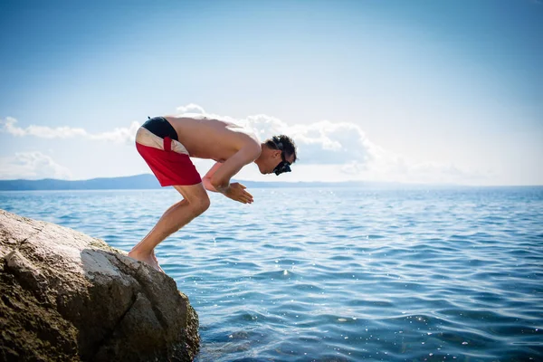 楽しみを持って、海にダイビングを取る若い男 — ストック写真