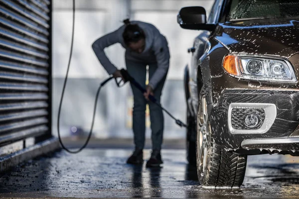 Frau wäscht ihr Auto in einer Autowaschanlage — Stockfoto