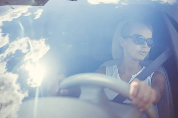 Giovane donna autista guida la sua auto unedr cocente Sole — Foto Stock