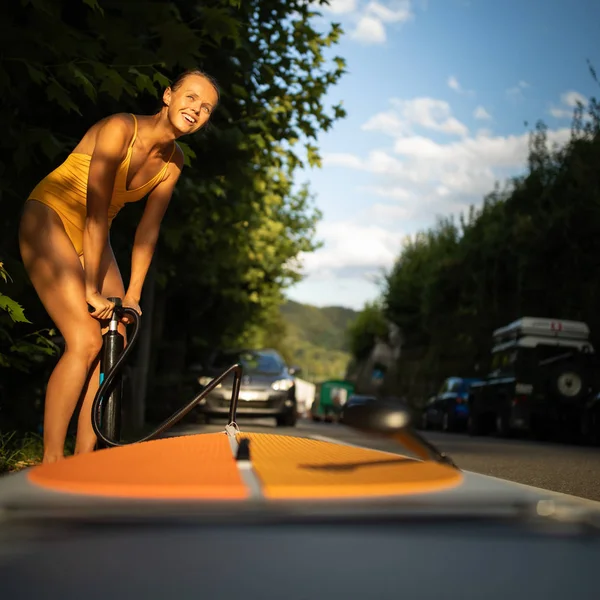 Hübsche, junge Frau paddelt auf einem schönen See — Stockfoto