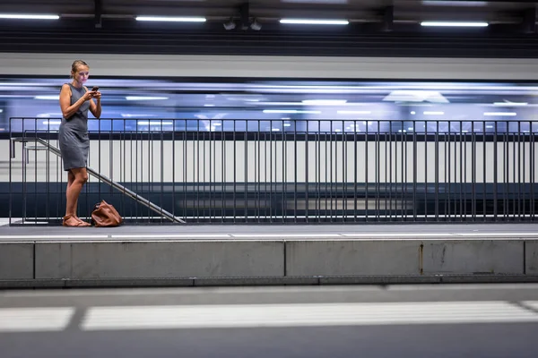 Mooie, jonge vrouwelijke commuters wachten op haar dagelijkse trein — Stockfoto