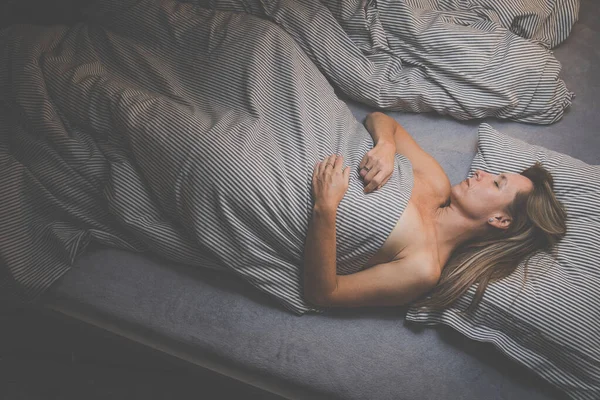 Pretty, middle-aged woman sleeping in her bed at home