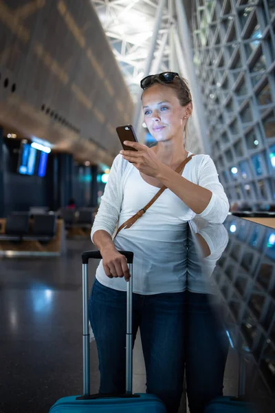 Mujer joven con su equipaje en un aeropuerto internacional — Foto de Stock