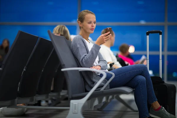 Mujer joven con su equipaje en un aeropuerto internacional, antes — Foto de Stock