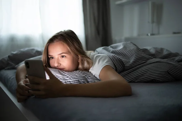 Όμορφη Νεαρή Γυναίκα Που Χρησιμοποιεί Έξυπνο Τηλέφωνό Της Στο Κρεβάτι — Φωτογραφία Αρχείου