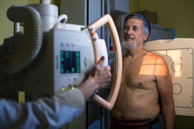 Modern bir hastanede Bilgisayarlı Eksen Tomografisi (CAT) taraması yapan güzel, genç bir kadın (renk tonlu görüntü; sığ DOF)