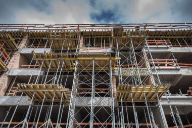 Modern şehir binası vinç ve mavi gökyüzü ile inşa ediliyor.