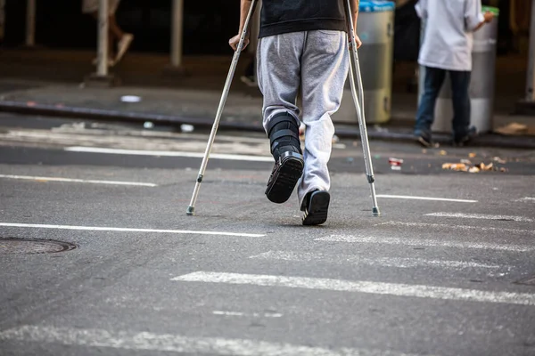 道路を渡る松葉杖を持つ男 — ストック写真