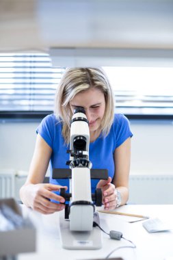 Güzel, yeni yapılmış gözlükleri ölçen kadın optometrist. Tam üstüne bastın.