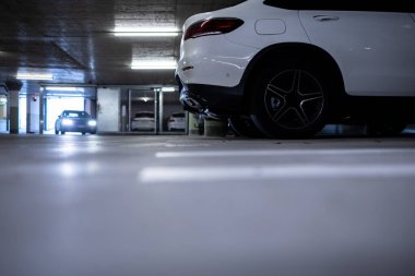 Yeraltı otoparkı. Garajda hiç insan olmayan arabalar. Otoparkın içinde bir sürü araba var. Otomobilli yeraltı otoparkı (renk tonlu resim)