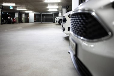 Yeraltı otoparkı. Garajda hiç insan olmayan arabalar. Otoparkın içinde bir sürü araba var. Otomobilli yeraltı otoparkı (renk tonlu resim)