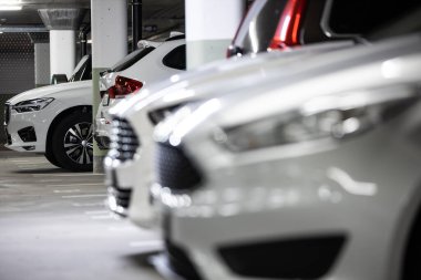 Yeraltı otoparkı. Garajda hiç insan olmayan arabalar. Otoparkın içinde bir sürü araba var. Otomobilli yeraltı otoparkı (renk tonlu resim)