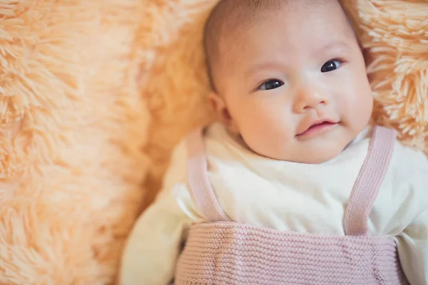 Asiatisch Baby Mädchen Auf Bett Mit Süß Fac lizenzfreie Stockfotos