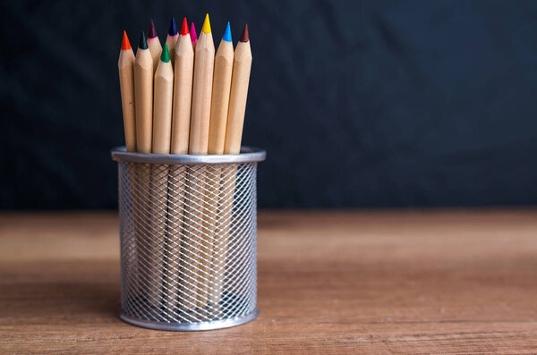 Crayons in the metal holder on the table