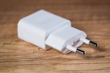 White mobile phone charger on the wooden table