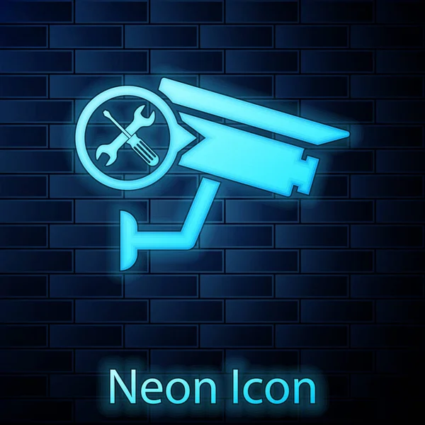 Glowing neon Security camera with screwdriver and wrench icon isolated on brick wall background. Adjusting, service, setting, maintenance, repair, fixing. Vector Illustration