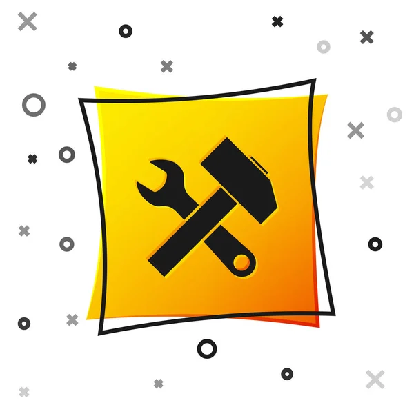 Negro Cruzado icono de martillo y llave inglesa aislado sobre fondo blanco. Herramientas de hardware. Botón cuadrado amarillo. Ilustración vectorial — Vector de stock