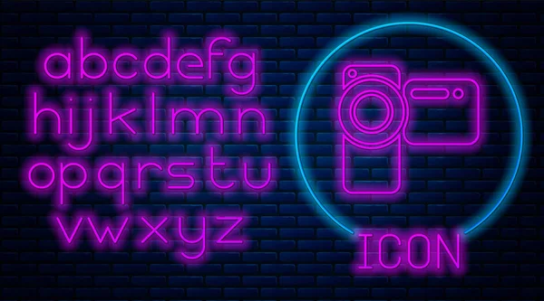 Glowing neon Cinema camera icon isolated on brick wall background. Video camera. Movie sign. Film projector. Neon light alphabet. Vector Illustration — Stock Vector