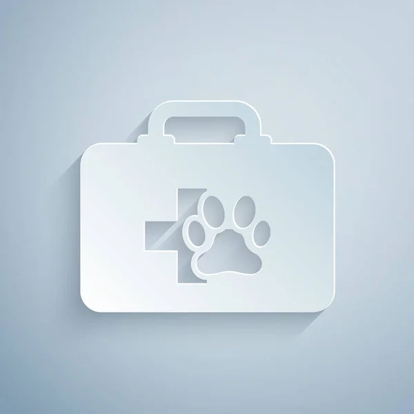 Paper cut Pet first aid kit icon isolated on grey background. Dog or cat paw print. Clinic box. Paper art style. Vector Illustration — Stock Vector