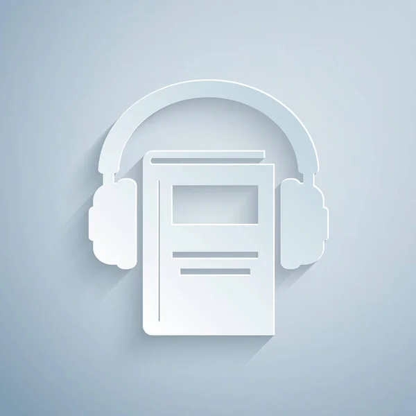 Corte de papel Icono de libro de audio aislado sobre fondo gris. Reserva con auriculares. Signo de audio guía. Concepto de aprendizaje en línea. Estilo de arte de papel. Ilustración vectorial — Archivo Imágenes Vectoriales